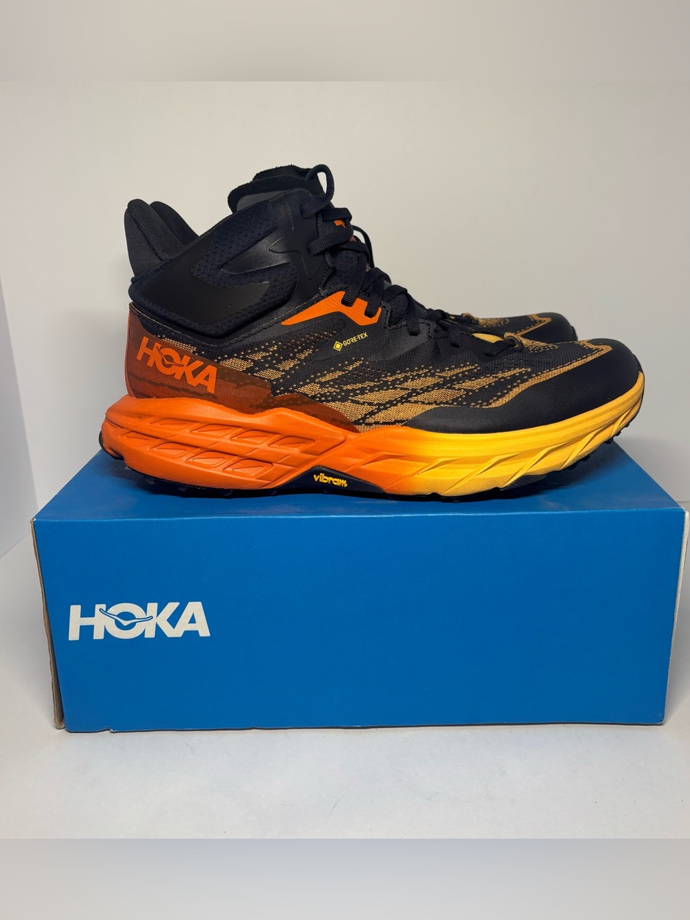 Hoka Men's Black Athletic Trail Shoe with Orange and Yellow Gradient Midsole